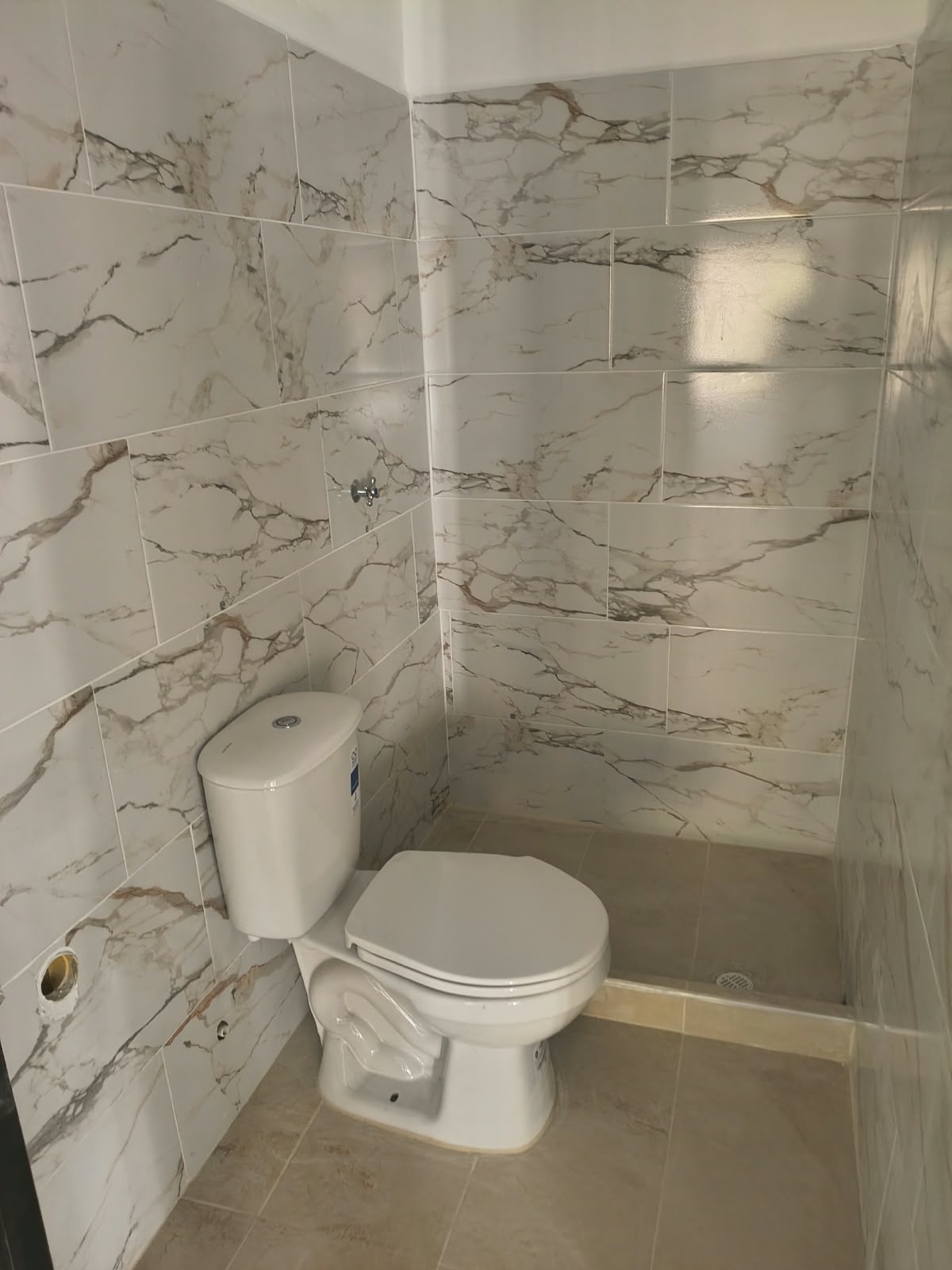 Baño con revestimiento de paredes y aparatos sanitarios